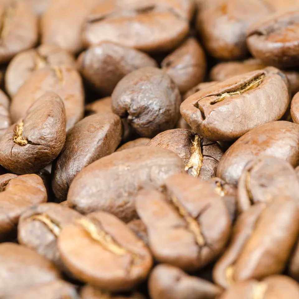 Macro close-up of light-roast coffee beans showing texture and centre creases