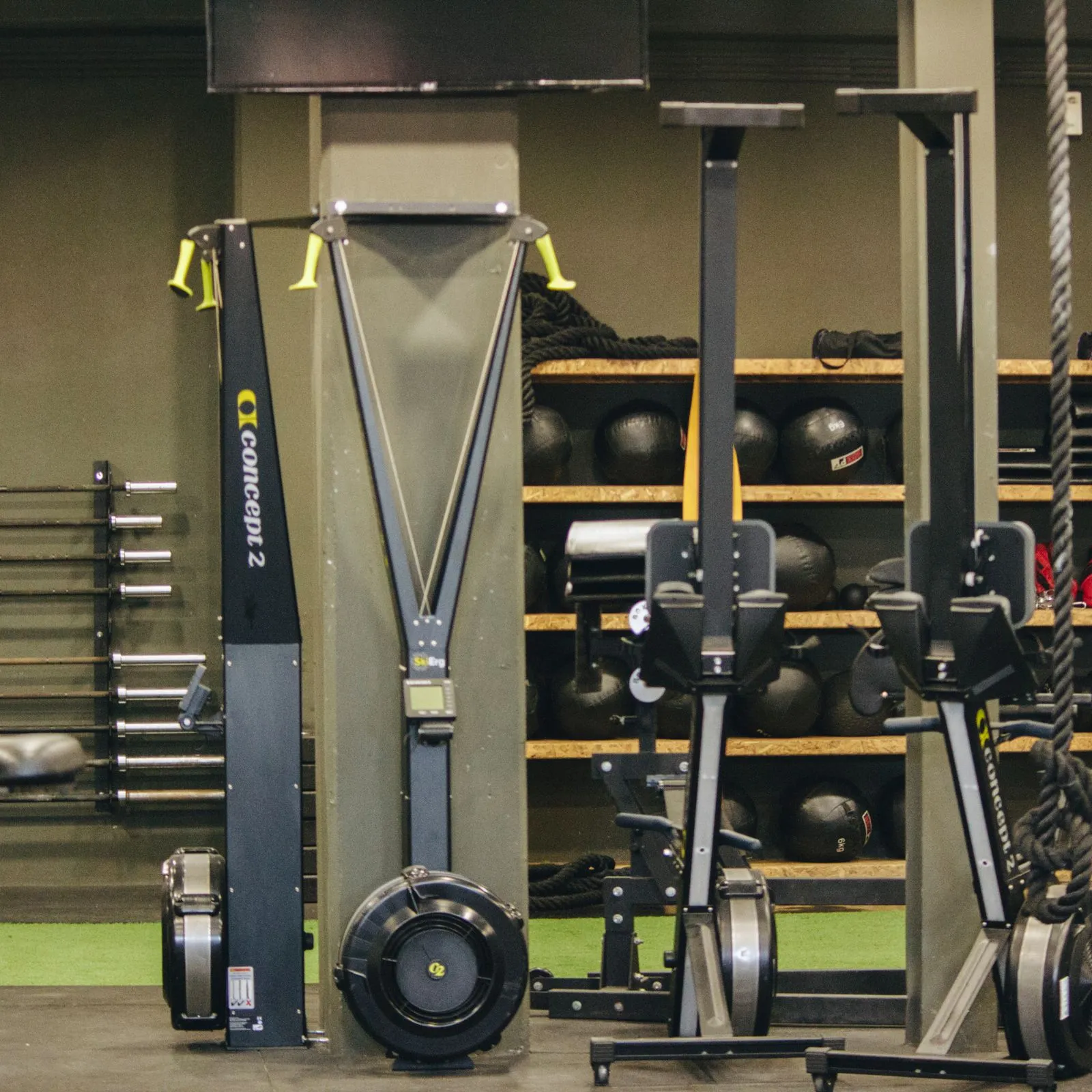 Functional training corner with ski ergometers, medicine balls and wooden shelving
